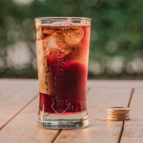 Das Glas zeigt eine Schichtung aus verschiedenen Farben, mit einer erfrischenden Mischung und einem Hauch von Frucht.